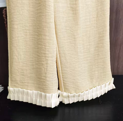Beige curtain with ruffled hem on a dark background