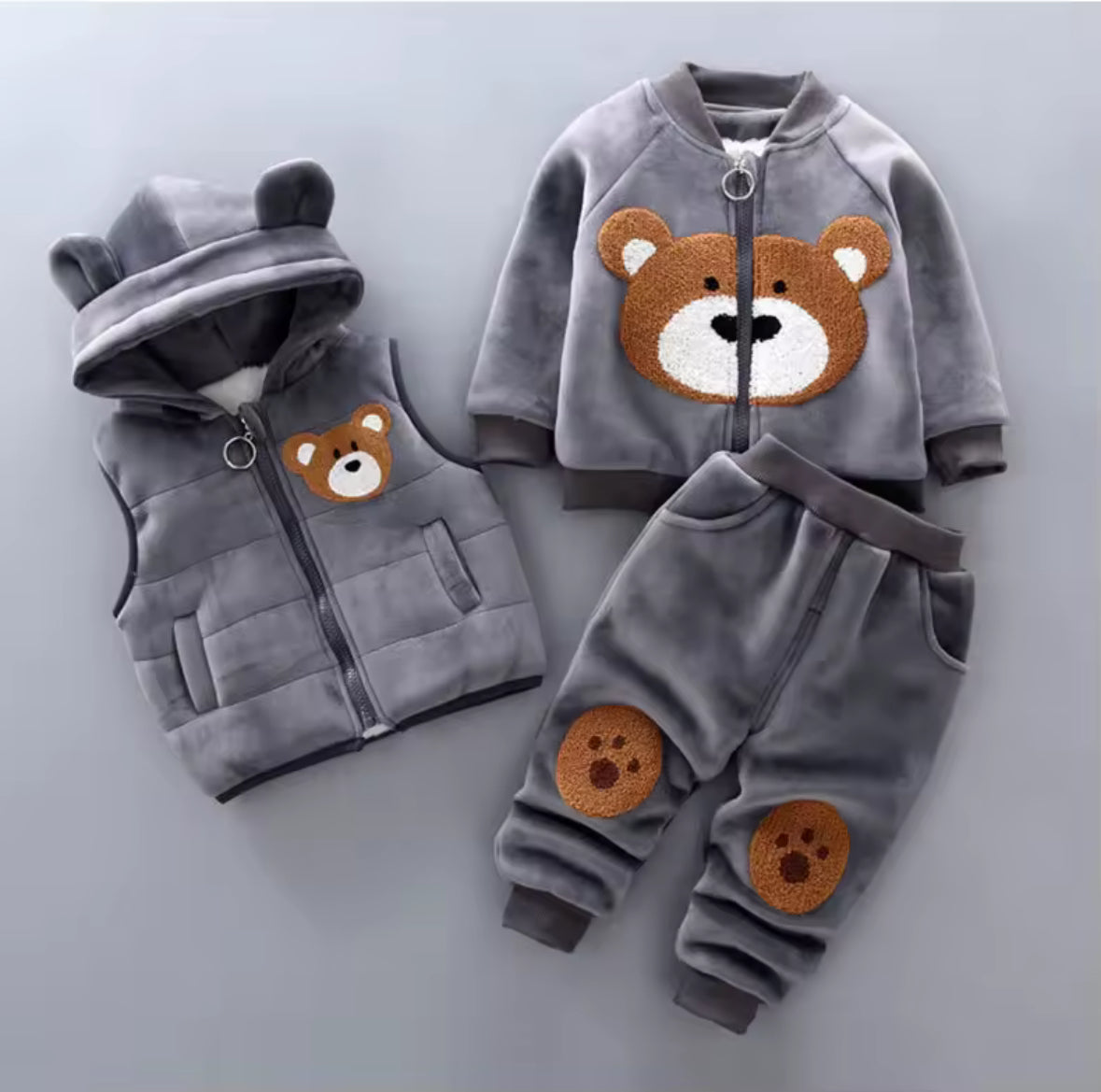 Children's clothing set with bear designs on a light gray background