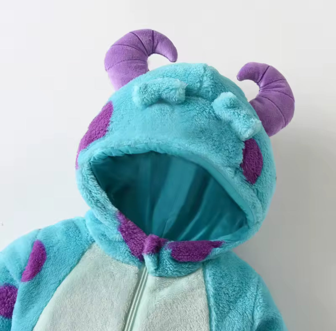Children's blue and purple hooded onesie with cartoonish design on a white background