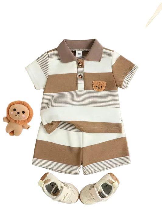 Striped baby outfit with brown and white colors, accompanied by baby shoes and a plush toy on a light gray background.