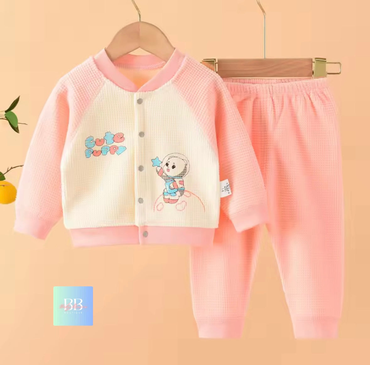 Children's pink and white outfit with cartoon design on a beige background