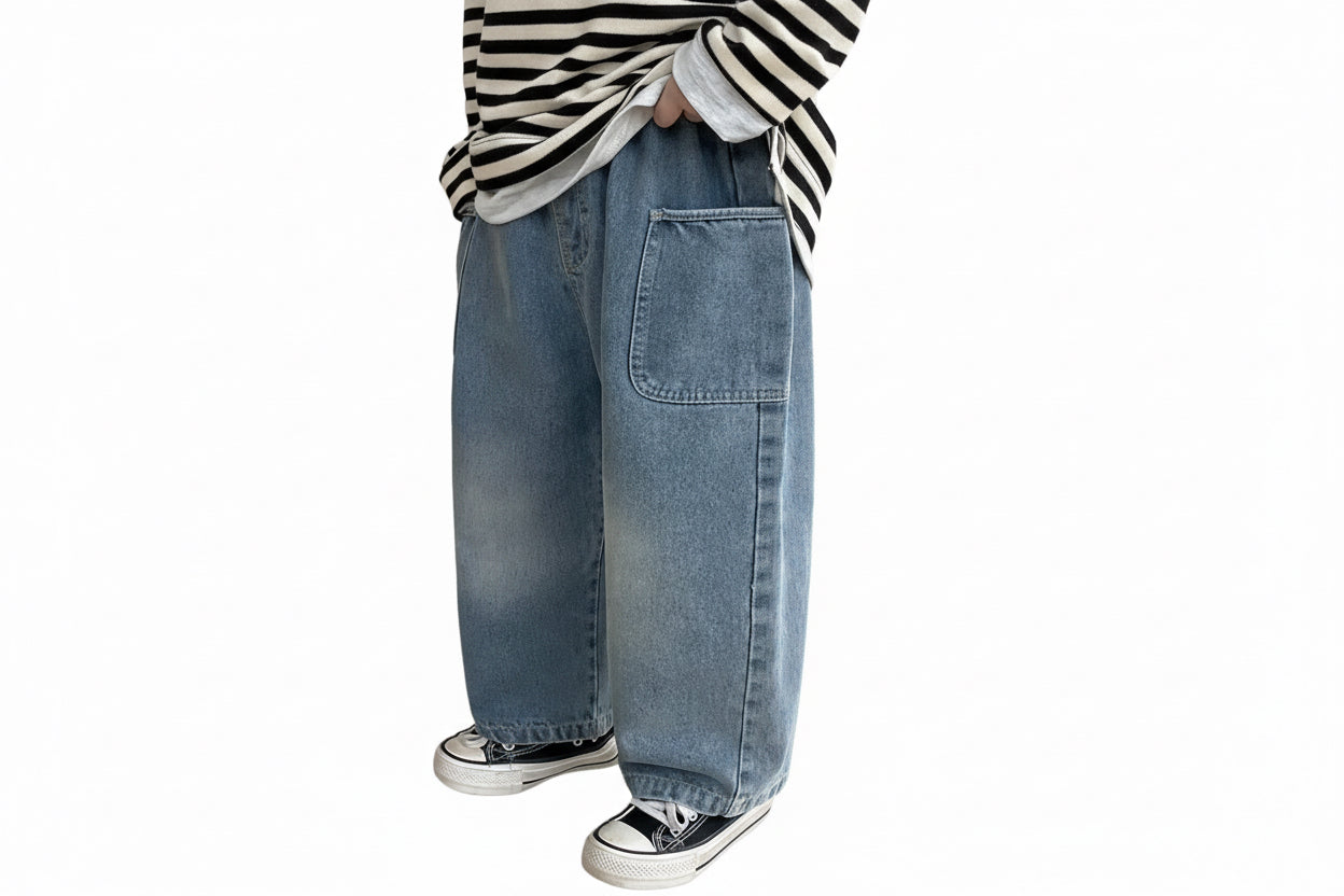 Person wearing blue jeans and a striped shirt in a room with wooden flooring and white cabinets.