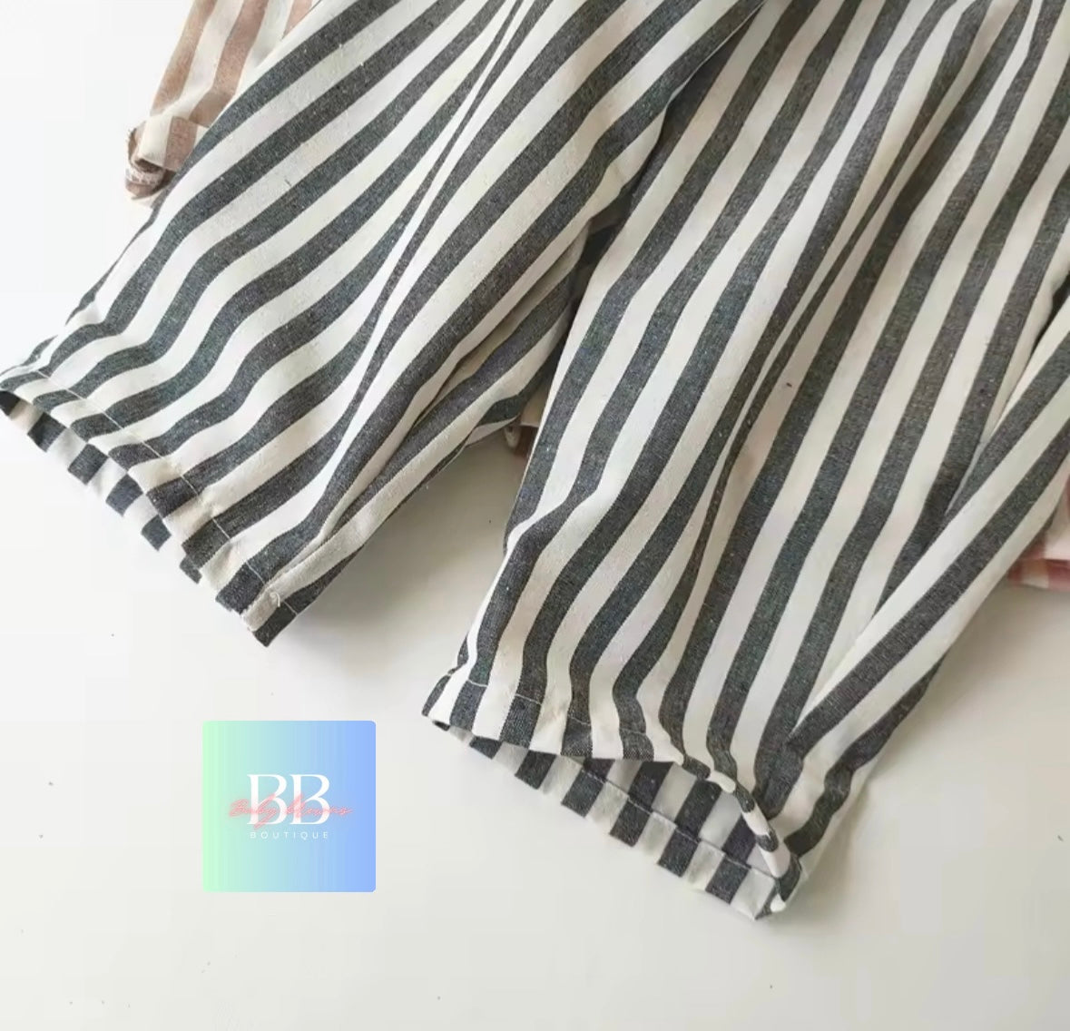 Striped pants with a brand logo in the corner on a light background