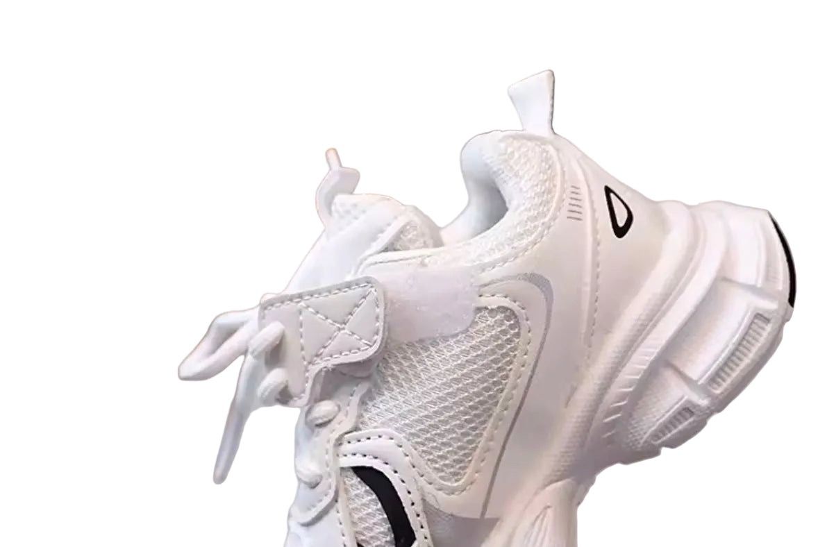 White sneaker with black accents on a reflective surface