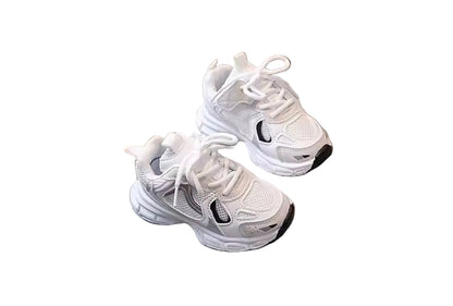 Pair of white sneakers on a gray surface with a wooden background