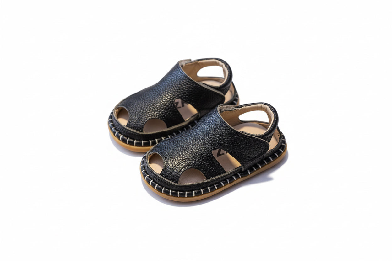 Pair of black sandals on a brown surface