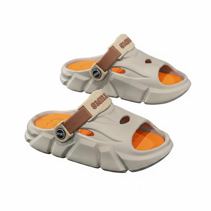 Pair of futuristic sandals with orange soles on a reflective surface.