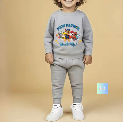 Child wearing a gray 'Paw Patrol' sweatshirt and pants on a beige background