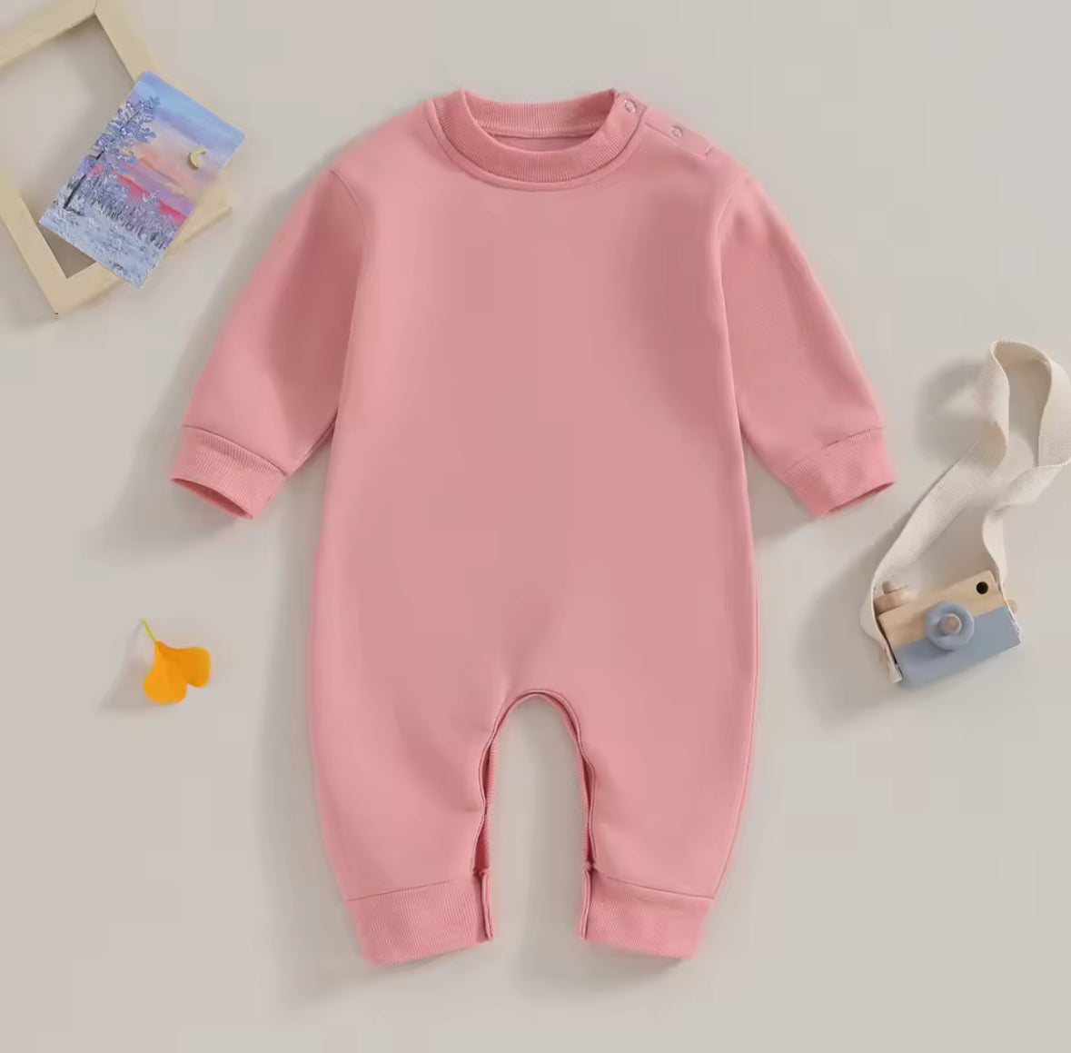 Pink baby onesie on a light gray background