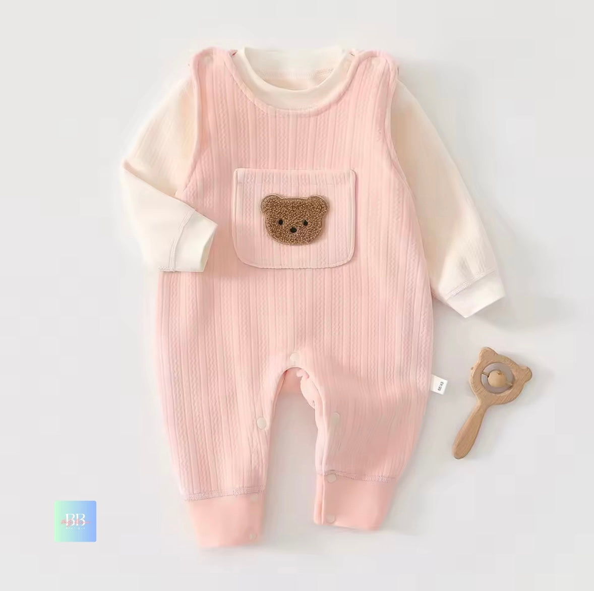 Pink baby romper with bear pocket on a white background