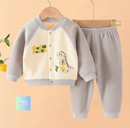 Children's outfit with jacket and pants on a hanger against a beige background