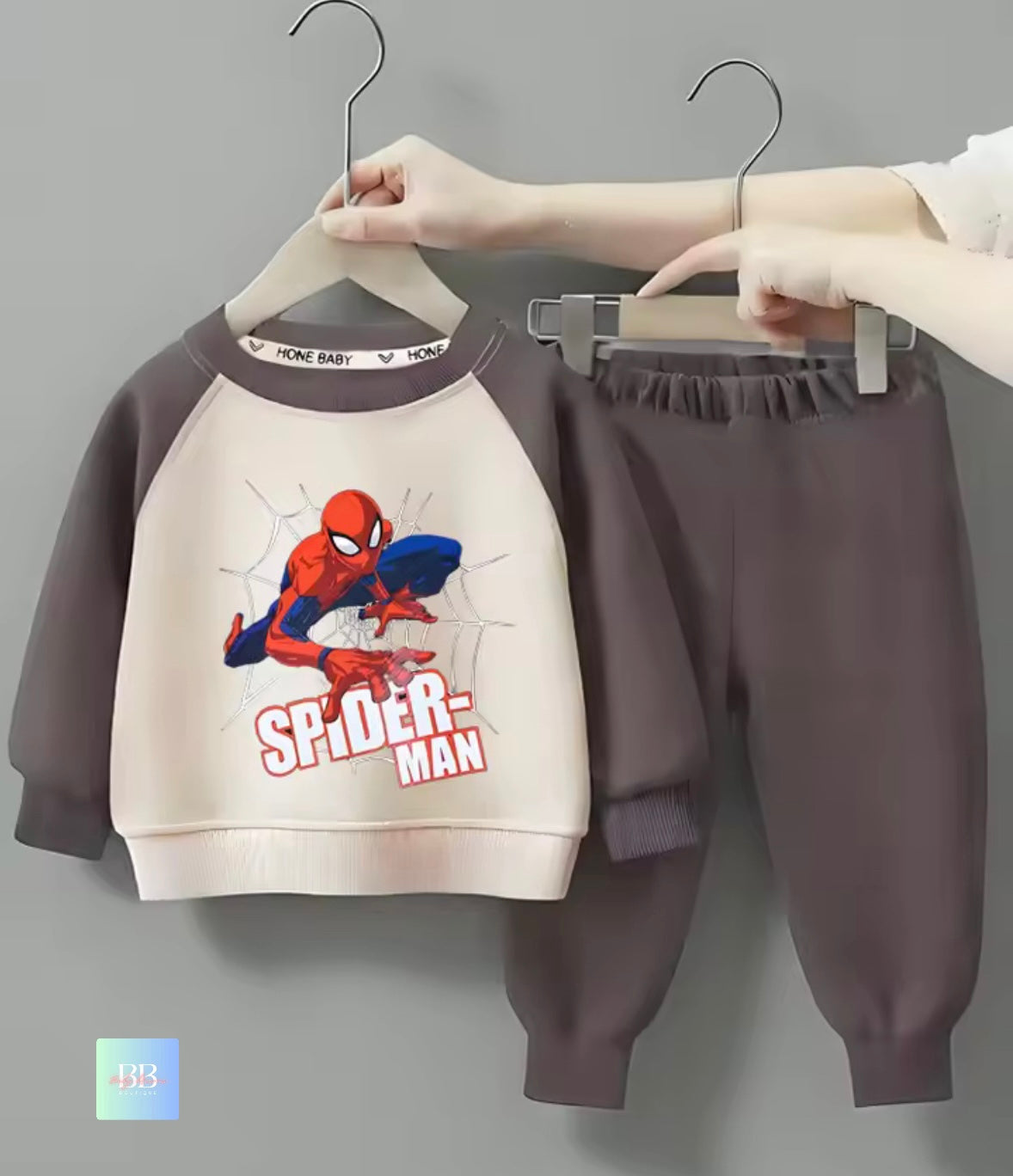 Children's Spider-Man outfit on hangers against a gray background