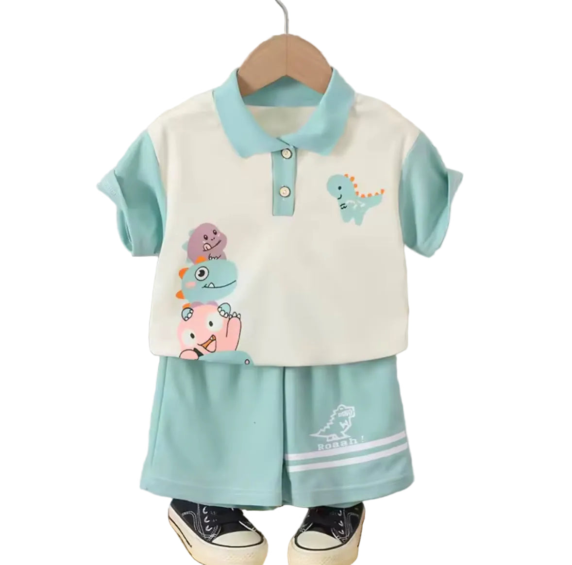 Children's outfit with cartoon designs on a hanger against a striped wall.