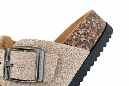 Close-up of a sandal with a textured strap and buckle on a blurred background