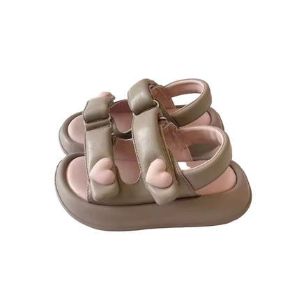 Pair of children's sandals on a desk with a keyboard in the background