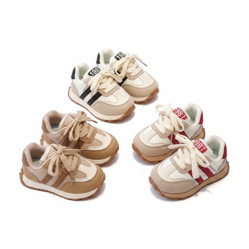 Set of children's sneakers on a glass surface with a blurred background