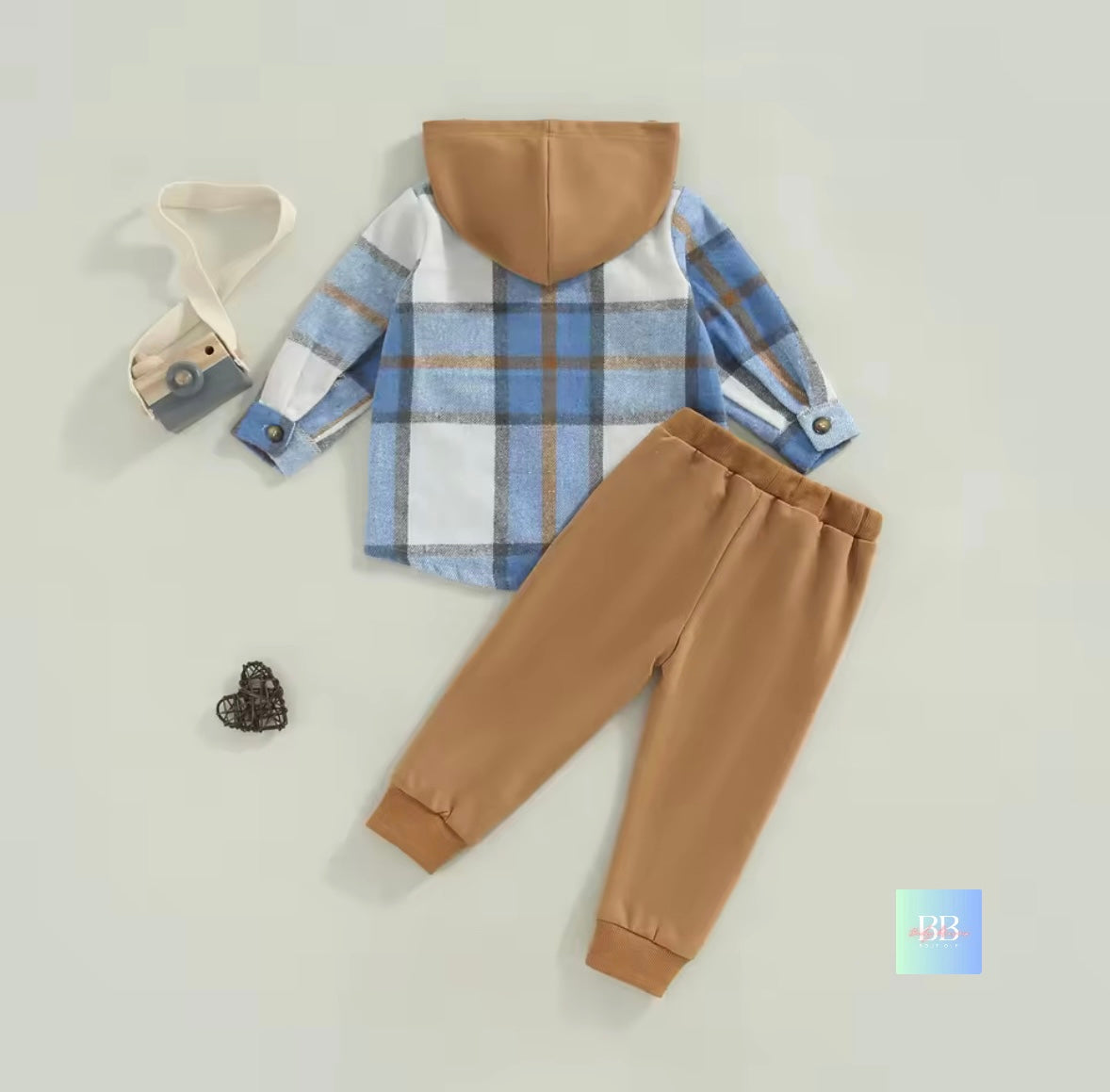Children's plaid shirt with brown hood and pants on a light gray background