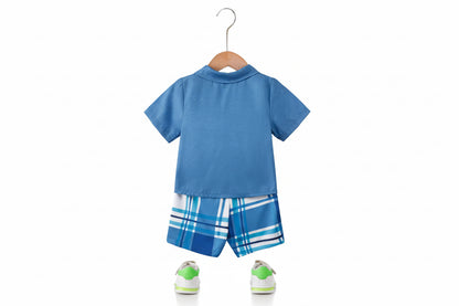 Blue children's outfit with plaid shorts on a hanger against a white wall.