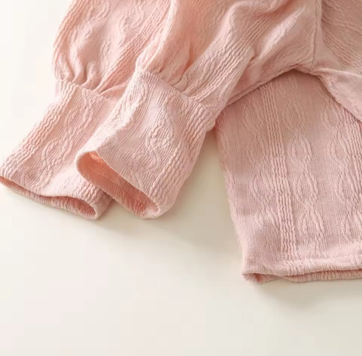 Close-up of pink textured fabric on a white background