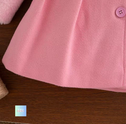 Close-up of a pink garment with a button on a wooden surface