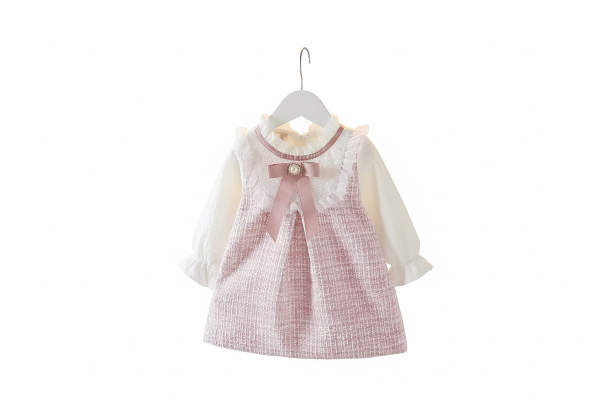 Children's dress with a bow on a hanger against a neutral background
