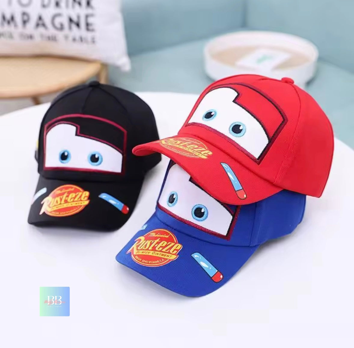 Two cartoon-themed hats in black, red, and blue on a white surface.