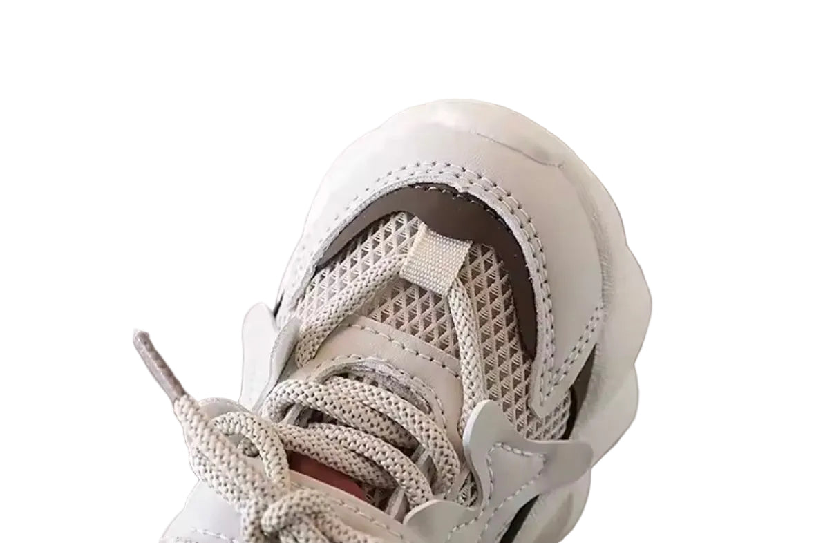 Close-up of a white sneaker with brown accents on a white background