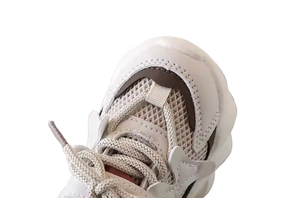 Close-up of a white sneaker with brown accents on a white background