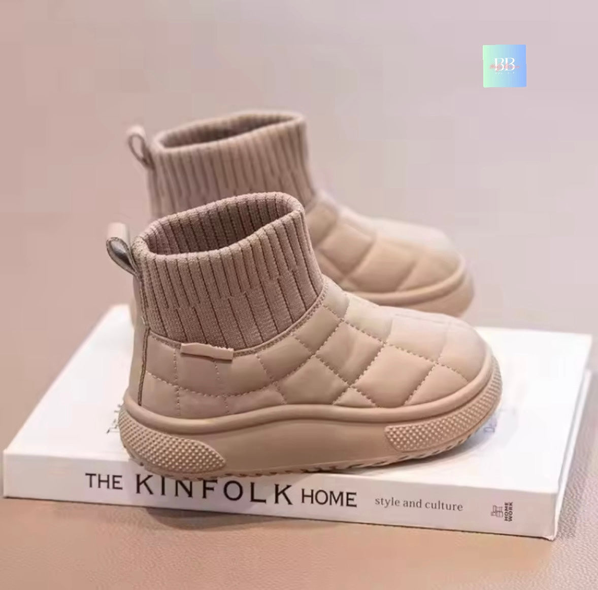 Beige quilted ankle boots on a white surface with 'The Kinfolk Home' book in the background.
