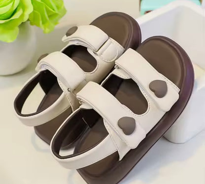 Pair of sandals with heart-shaped designs on a light background