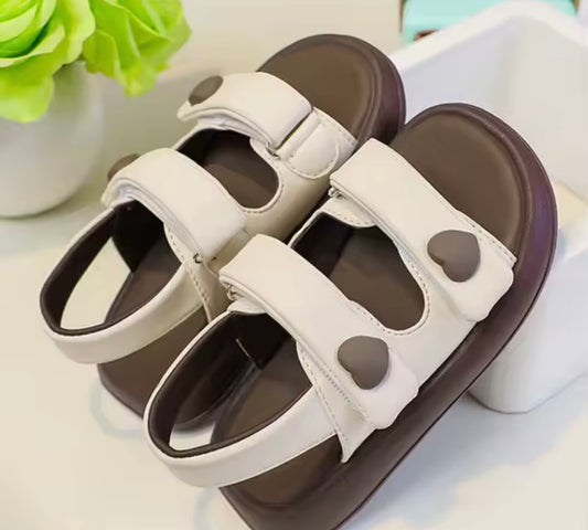 Pair of sandals with heart-shaped designs on a light background