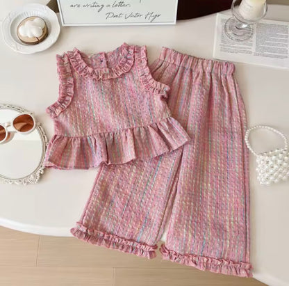 Pink ruffled outfit on a white surface with decorative items.