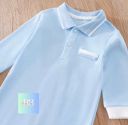 Light blue baby polo shirt with white trim on a wooden surface