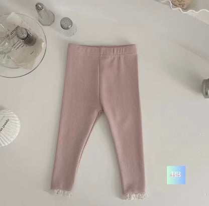 Pink leggings on a white surface with decorative items.