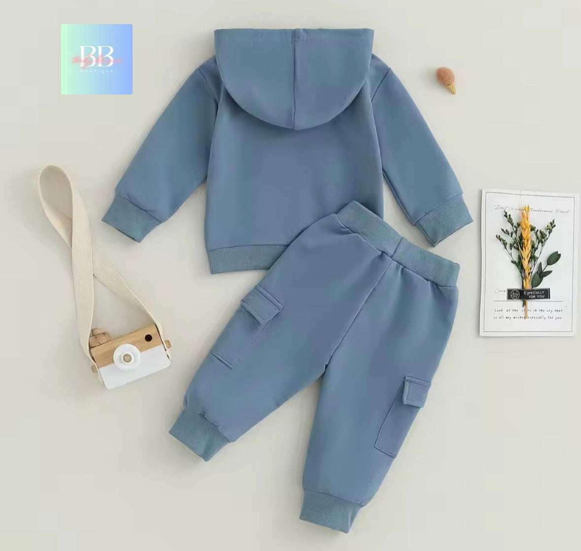 Blue children's hoodie and pants set on a light background with a BB logo in the corner.