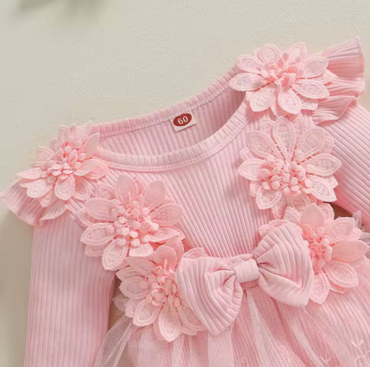 Pink dress with floral embellishments on a light background