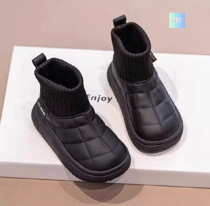 Pair of black quilted ankle boots on a white surface with 'Enjoy' text.