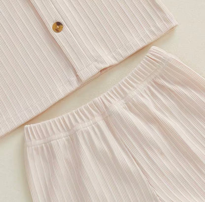 Close-up of a light pink textured shirt and pants on a beige background