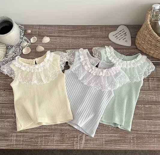 Three ribbed tank tops with lace trim on a wooden surface.