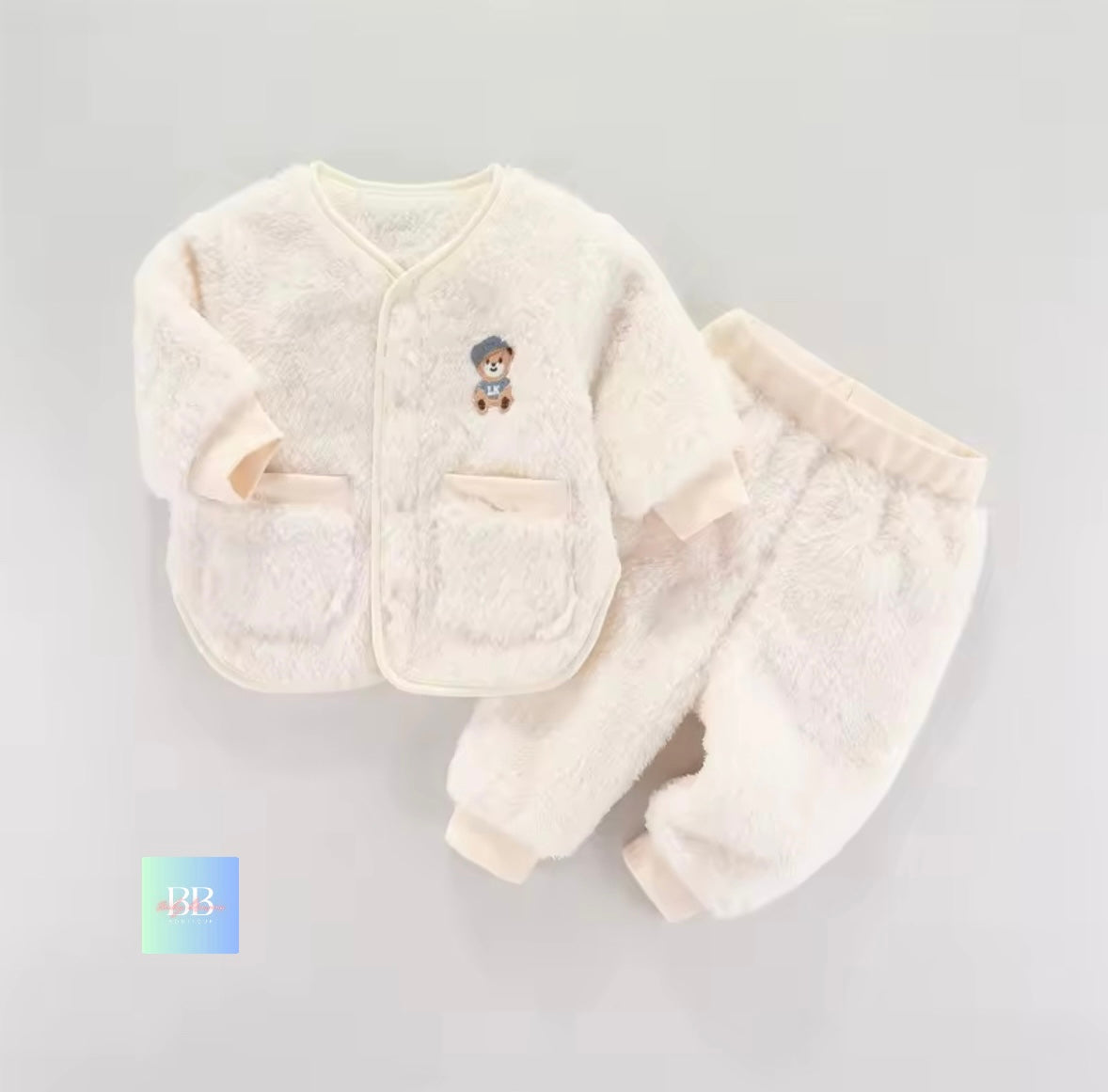 White baby outfit with a jacket and pants on a gray background