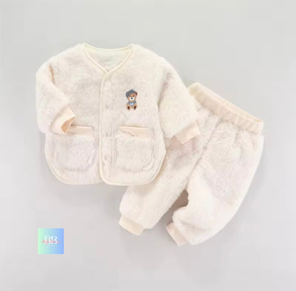 White baby outfit with a jacket and pants on a gray background