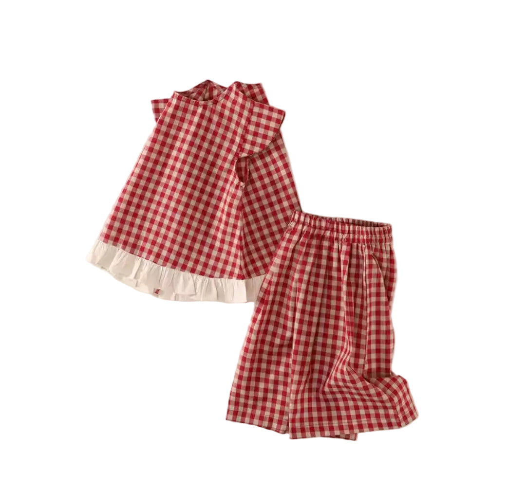 Red and white checkered outfit with ruffled details on a light beige background