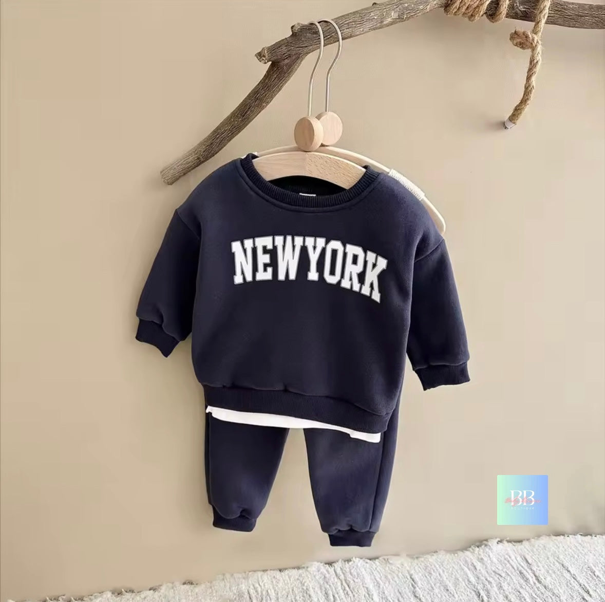 Navy blue children's sweatshirt and pants set with 'New York' text on a beige background