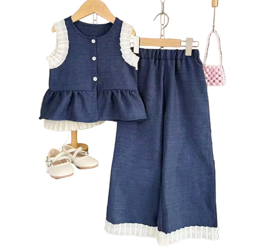 Children's blue outfit with white ruffles on a wooden hanger against a wooden wall.