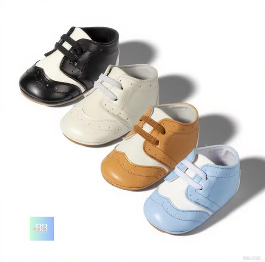 Set of three children's shoes in black, white, and brown on a white background