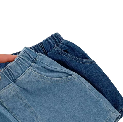 Two pairs of blue jeans stacked on a textured white surface