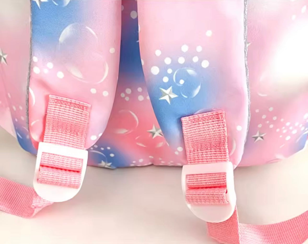Pink and blue backpack with star and bubble designs on a white background