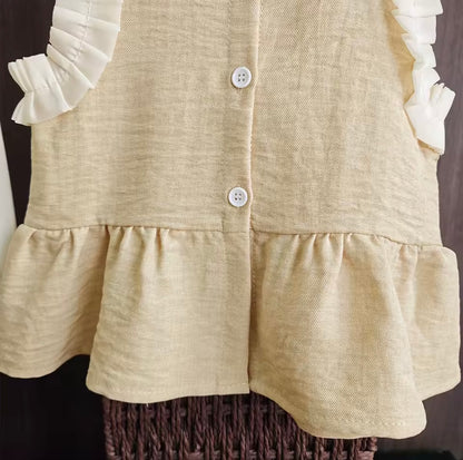 Beige dress with ruffled sleeves and bottom on a dark background