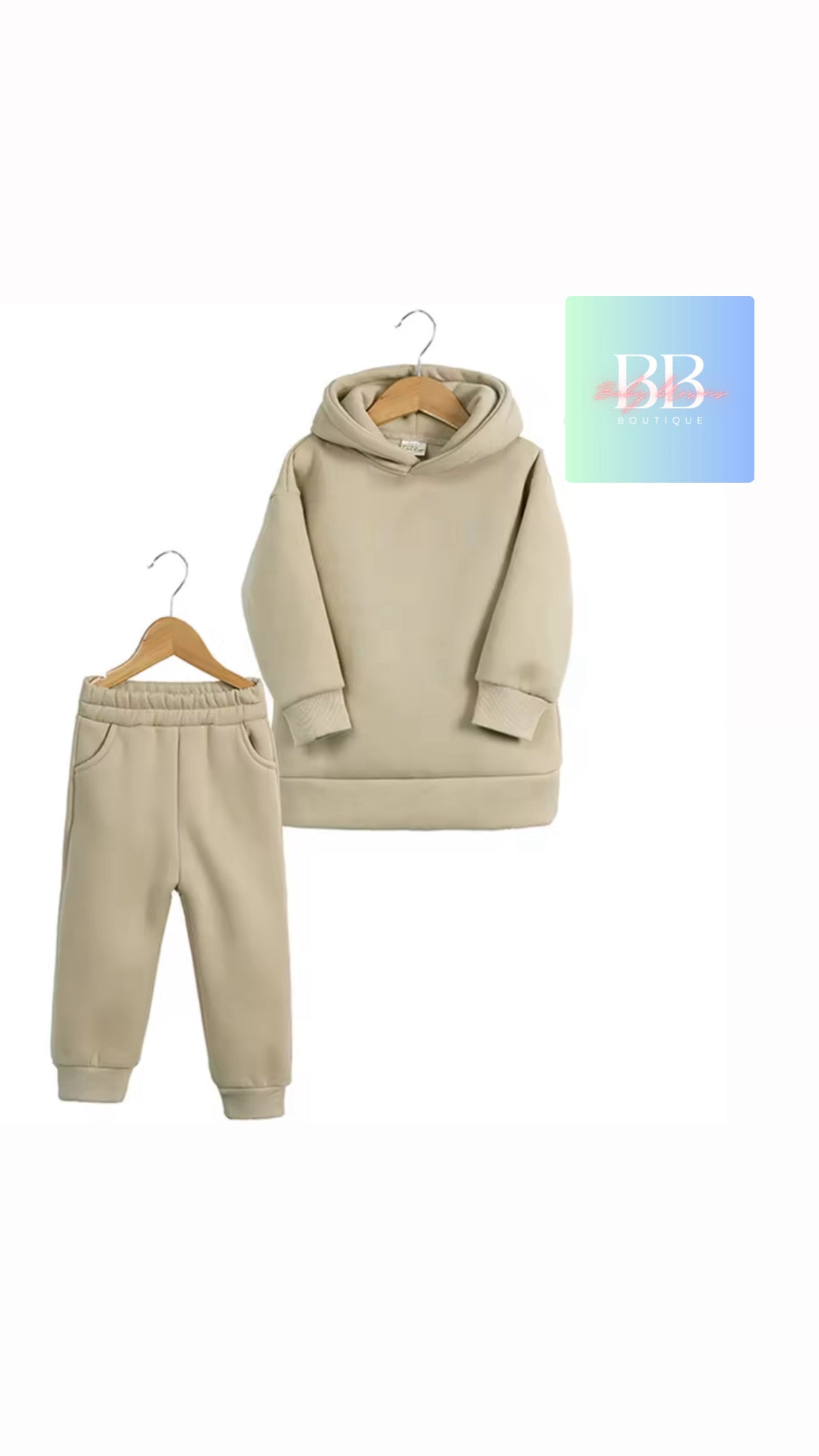 Beige hoodie and jogger set on hangers with a visible brand logo on a white background