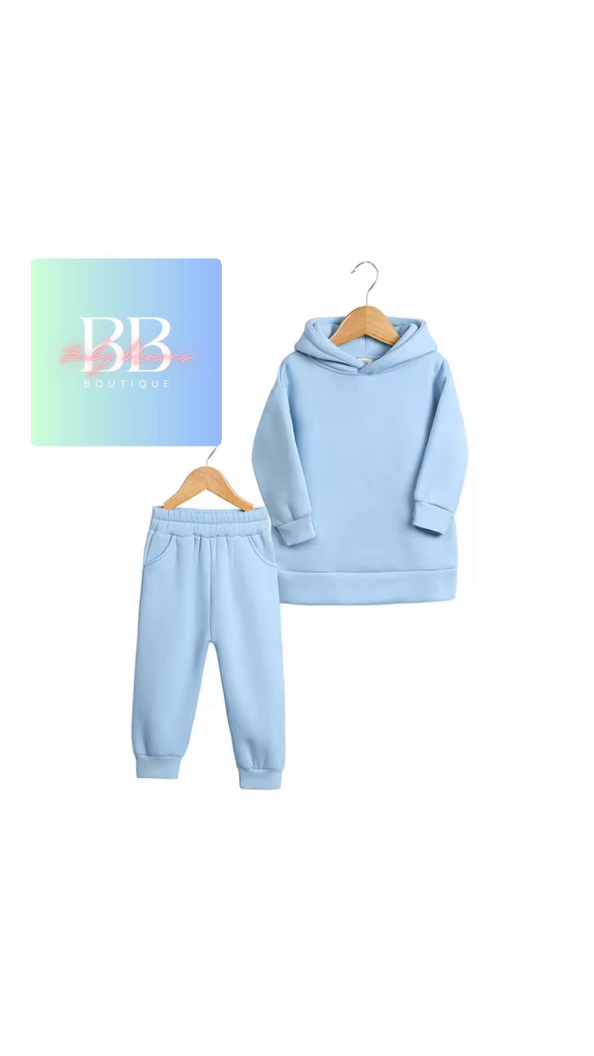 Light blue hoodie and pants set on hangers with a visible brand logo on a white background